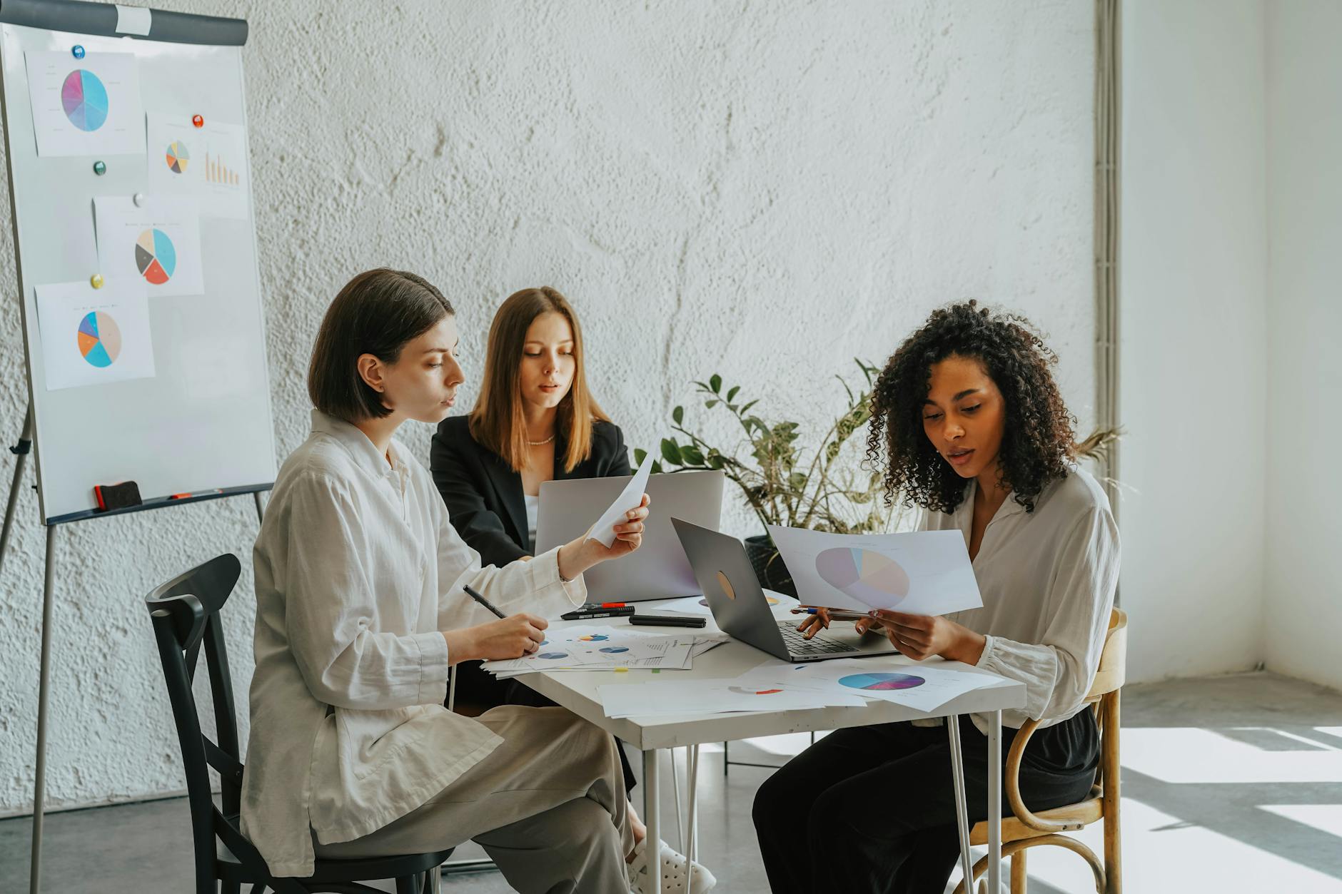 a group of women sitting at a desk working together